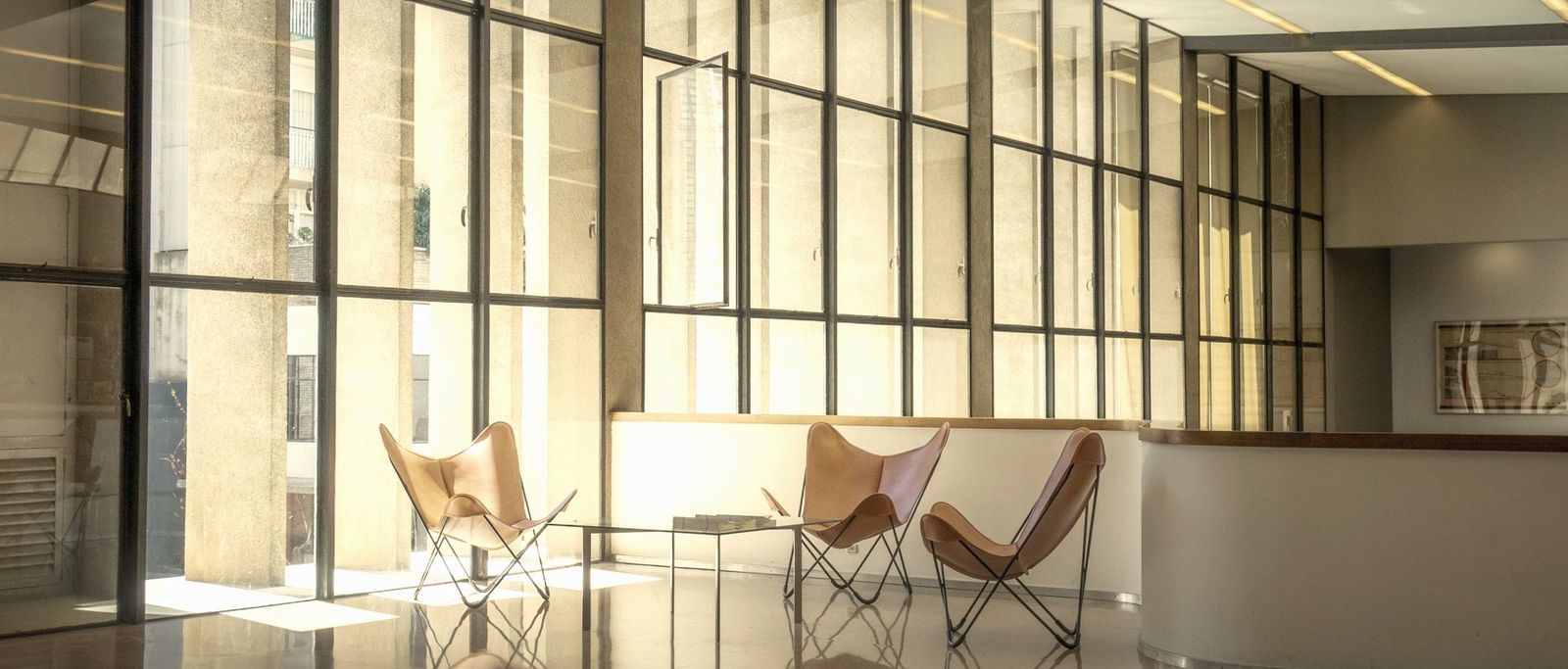 Recepção de escritório corporativo com poltronas e luz natural