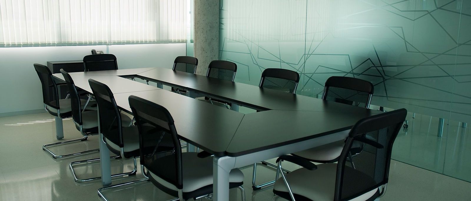 Ambiente corporativo sóbrio, com cadeiras e luz natural